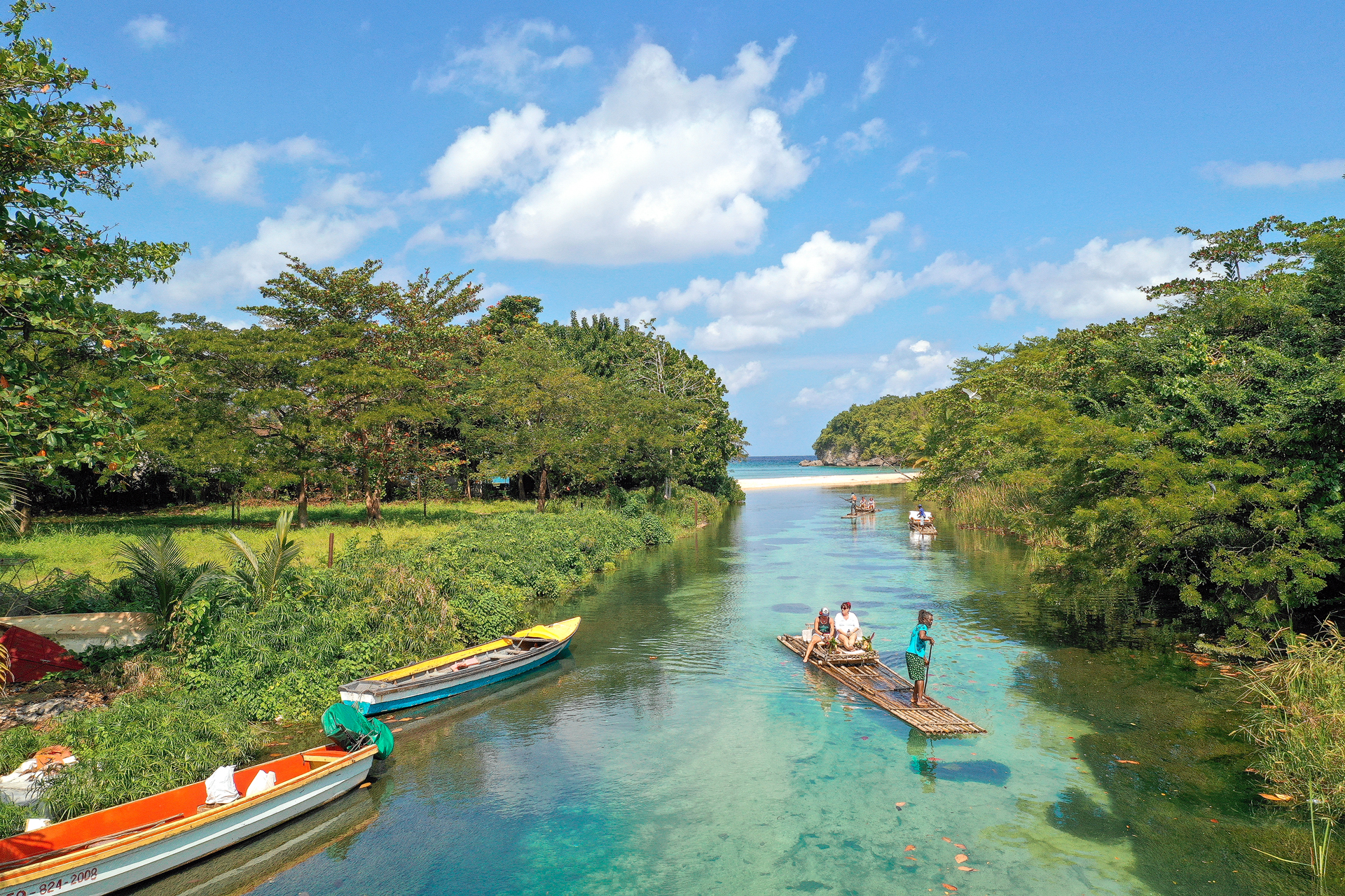 Boats on the green river between forested banks near Ocho Rios