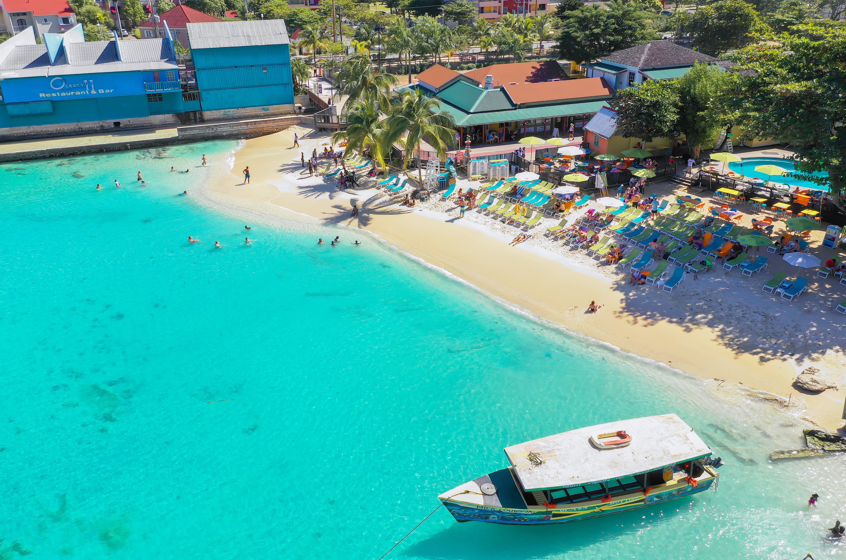Aerial view of an Ocho Rios beach with boats and umbrellas along the sand